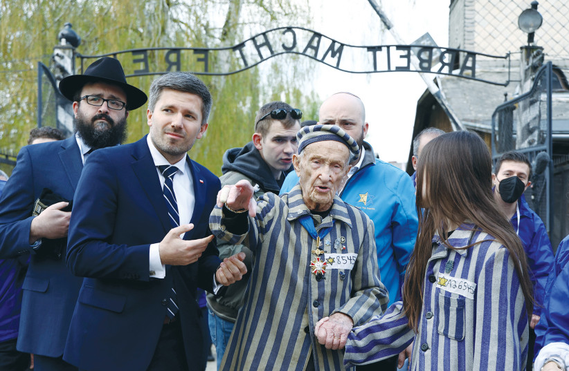  HOLOCAUST SURVIVOR Edward Mosberg and his relatives take part in the annual International March of the Living through the grounds of the former Auschwitz death camp, in Oswiecim, Poland, last year. (credit: KACPER PEMPEL/REUTERS)