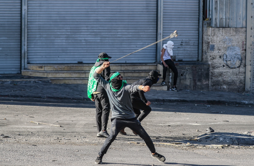 Palestinians clash with Israeli security forces during a protest in the West Bank town of Al Ram, north of Jerusalem, January 27, 2023.  (photo credit: JAMAL AWAD/FLASH90)
