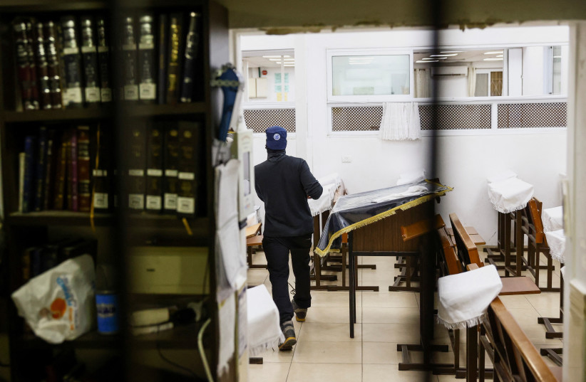 Security personnel scans a synagogue following a shooting attack in Neve Yaacov (credit: REUTERS/RONEN ZEVULUN)