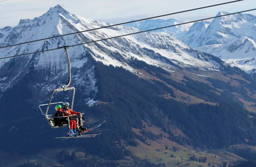  People sit on a chair-lift in Leysin (photo credit: REUTERS/DENIS BALIBOUSE)