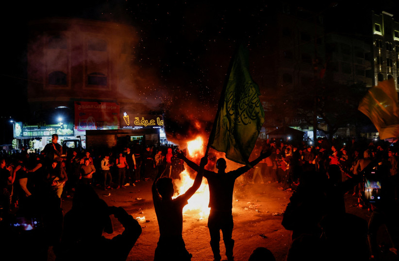  Palestinians celebrate following Jerusalem's shooting attack, in Gaza City January 27, 2023.  (photo credit: REUTERS/MOHAMMED SALEM)