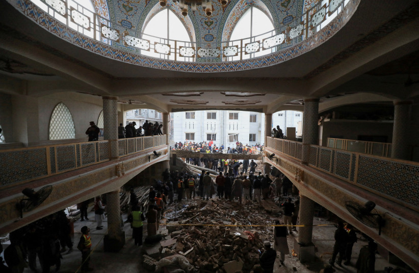  People and rescue workers gather to look for survivors under a collapsed roof, after a suicide blast in a mosque in Peshawar, Pakistan January 30, 2023 (photo credit: REUTERS/FAYAZ AZIZ)