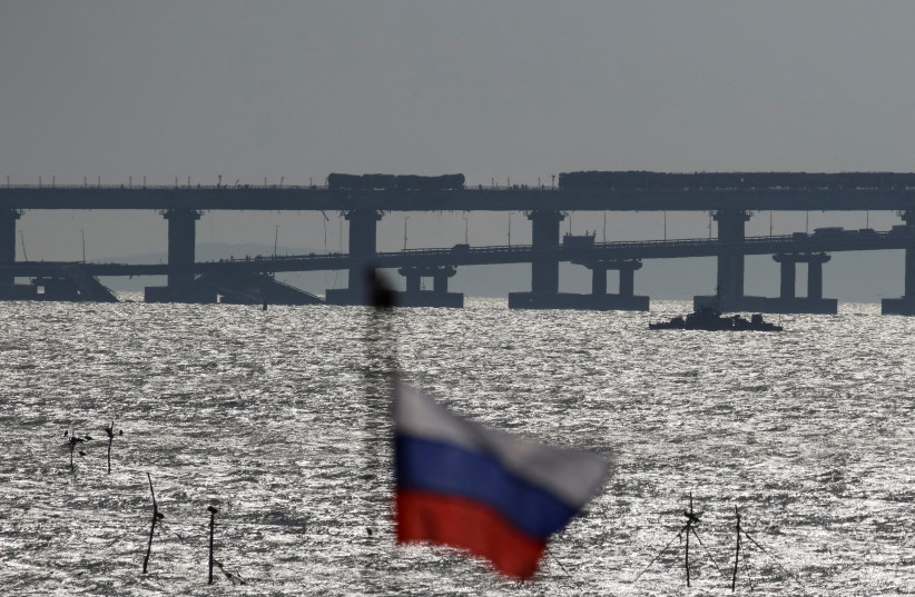  Russian national flag flies with backdrop of the Kerch bridge after an explosion destroyed part of it, in the Kerch Strait, Crimea, October 8, 2022 (photo credit: REUTERS/STRINGER)