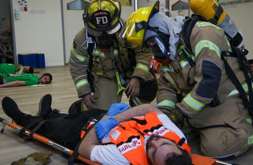  Firefighters attend to a United Hatzalah volunteer who had a simulated injury during the drill  (photo credit: UNITED HATZALAH‏)