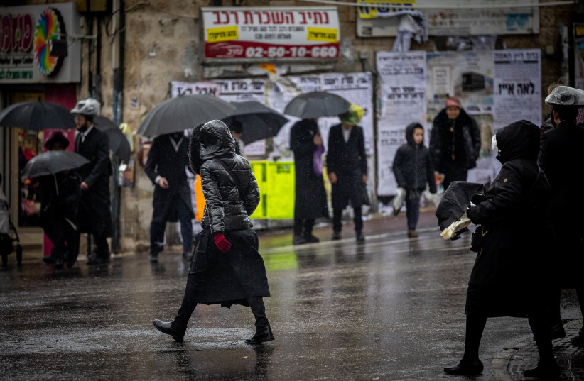  Ultra Orthodox Jews seen in the street of the ultra orthodox neighborhood of Meah Shearim on a rainy day, February 1, 2023.  (credit: YONATAN SINDEL/FLASH90)