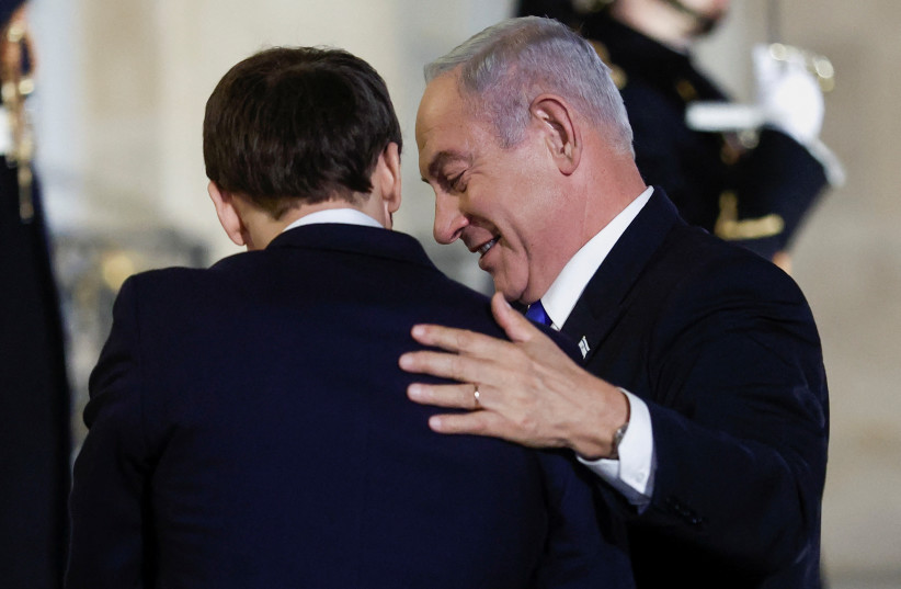  French President Emmanuel Macron welcomes Israeli Prime Minister Benjamin Netanyahu as he arrives for a dinner at the Elysee Palace, in Paris, France, February 2, 2023.  (credit: BENOIT TESSIER/REUTERS)