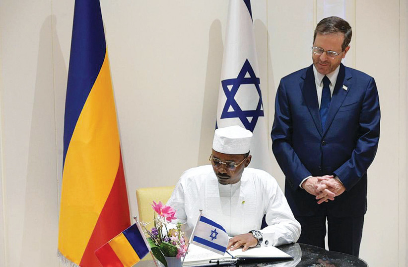 MAHAMAT DÉBY, the president of Chad, signs the guest book at the President’s Residence, as President Isaac Herzog looks on. (photo credit: AMOS BEN GERSHOM/GPO)