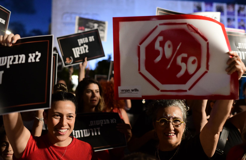  Women hold signs as they protest for women equality, in Tel Aviv on August 23, 2022.  (photo credit: TOMER NEUBERG/FLASH90)