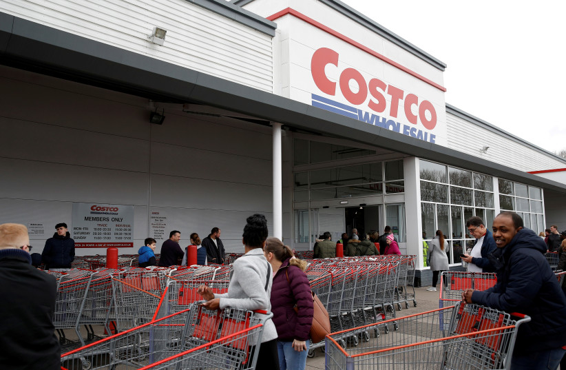  People form a long queue as they wait for the Costco wholesalers to open in Manchester, Britain March 15, 2020. (photo credit: PHIL NOBLE/REUTERS)