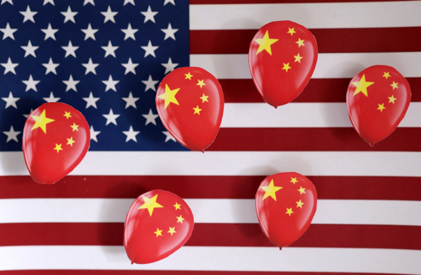  Printed balloons with Chinese flag are placed on a U.S. flag in this illustration taken February 5, 2023 (photo credit: REUTERS/DADO RUVIC)