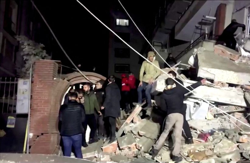 People search through rubble following an earthquake in Diyarbakir, Turkey February 6, 2023 in this still image taken from video. (photo credit: REUTERS/via Reuters TV)