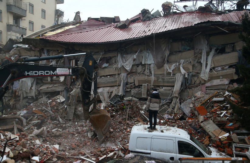 Un homme se tient devant un bâtiment effondré après un tremblement de terre à Kahramanmaras, en Turquie, le 6 février 2023. (Crédit : REUTERS/CAGLA GURDOGAN)