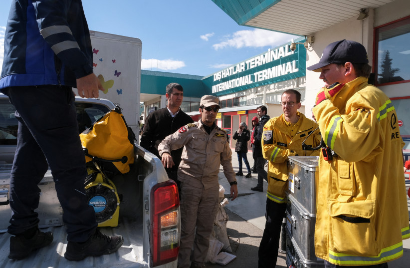 Rescue workers from Germany's fire and rescue service handle equipment to be used to help people affected by the deadly earthquake as Umur Zamanoglu, Turkish search and rescue team leader coordinates arrivals of foreign aid workers outside Adana Airport, in Adana, Turkey, February 7, 2023. (credit: REUTERS/EMILIE MADI)