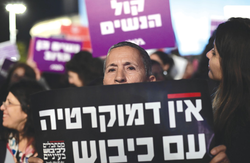  A PROTESTER holds a sign that reads ‘There can be no democracy alongside occupation,’ at a demonstration in Tel Aviv, this week.  (photo credit: TOMER NEUBERG/FLASH90)