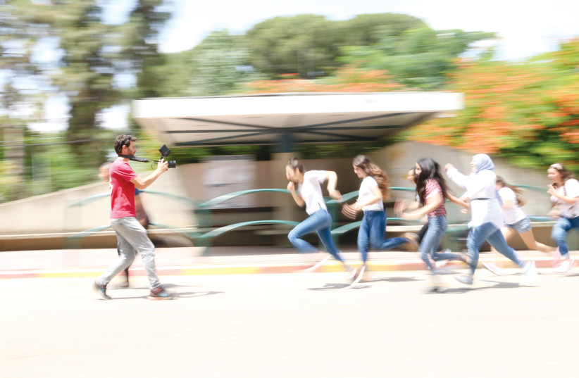  Left: Gil Ramon films students on the move (photo credit: Raphael Ruta)