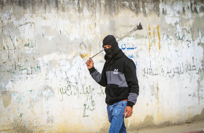  A PALESTINIAN YOUTH in Beita, near Nablus, faces Israeli security forces late last month.  (photo credit: NASSER ISHTAYEH/FLASH90)