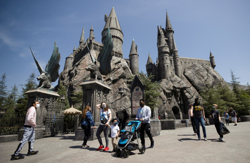  Guests walk by Hogwarts Castle inside The Wizarding World of Harry Potter area on reopening day of Universal Studios Hollywood during the outbreak of the coronavirus disease (COVID-19), in Universal City, California, US, April 15, 2021. (credit: REUTERS/MARIO ANZUONI)