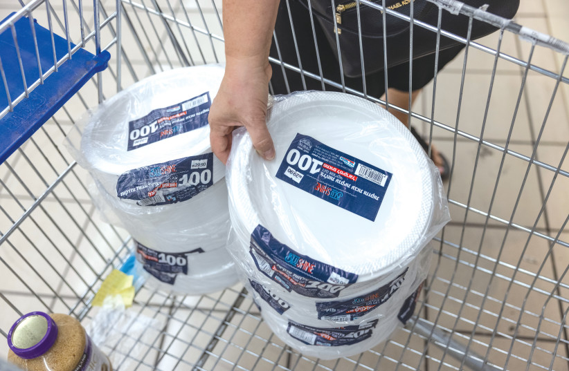  A SHOPPER stocks up on disposable plastic plates. The government’s decision to cancel the sales tax on single-use plastic tableware was bad news for anyone who cares about the environment, says the writer.  (photo credit: YONATAN SINDEL/FLASH90)
