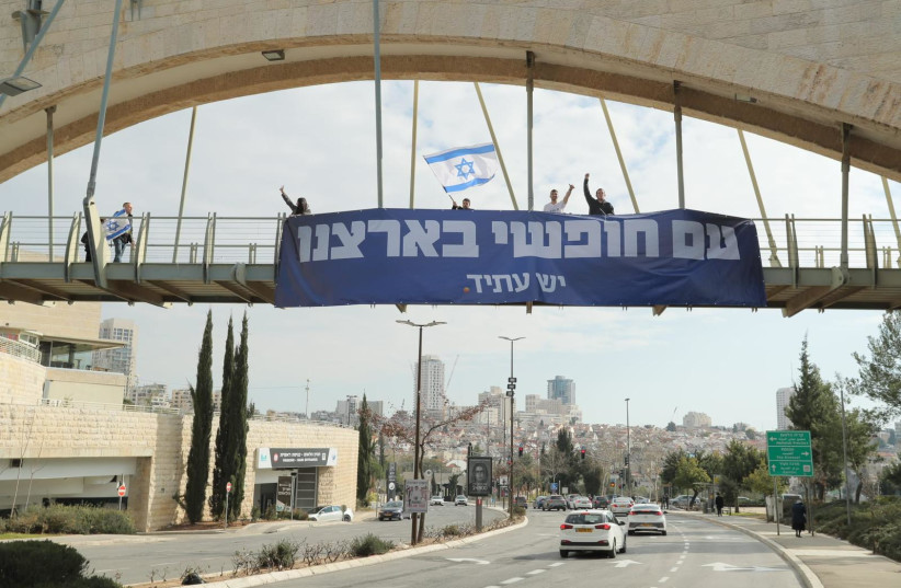  Yesh Atid protestors demonstrating on a bridge over a busy street in Jerusalem (photo credit: Ronen Harish)