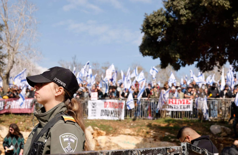  An Israeli police officer standing near protesters near the Knesset (photo credit: MARC ISRAEL SELLEM)