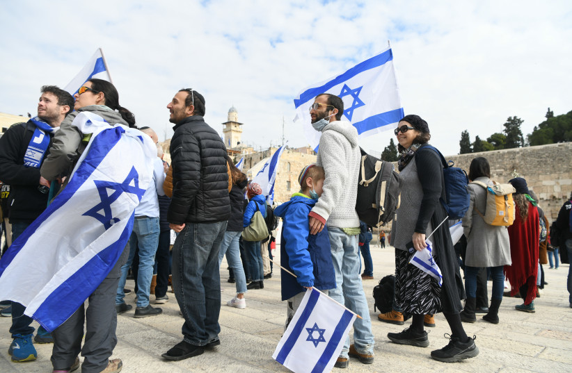  Israelis wave to Israeli flag as they protest the government's planned judicial reforms, at the Western Wall in Jerusalem's Old City. February 13, 2023.  (credit: Arie Leib Abrams/Flash90)