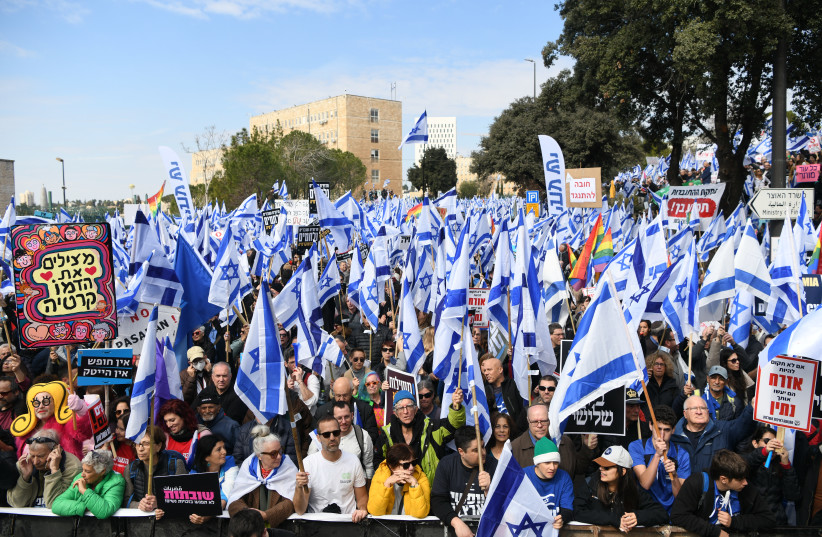  Thousands wave the Israeli flag as they protest against the judicial overhaul, outside the Knesset in Jerusalem. February 13, 2023. (credit: Arie Leib Abrams/Flash90)