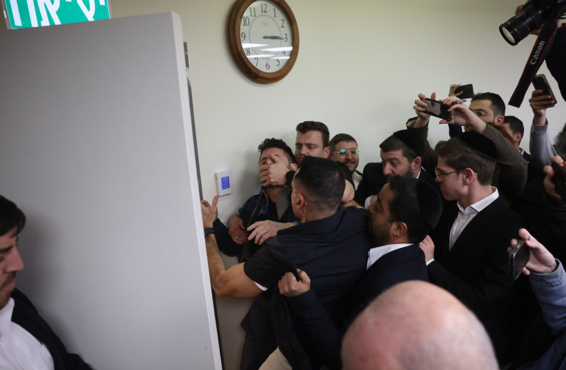  Security guards escort a demonstrator protesting against ead of the Shas party Arye Deri, during a faction meeting, at the Knesset, the Israeli parliament in Jerusalem, on February 13, 2023 (photo credit: YONATAN SINDEL/FLASH90)
