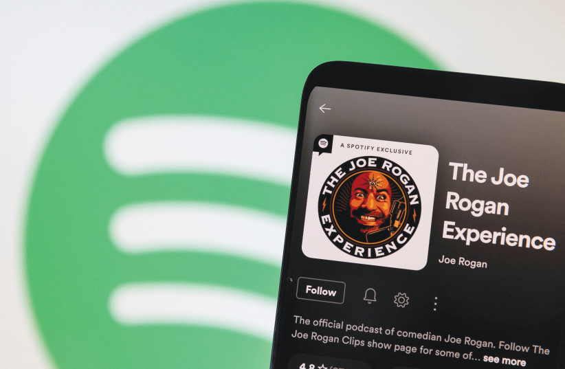  JOE ROGAN’S profile is displayed in front of a Spotify logo: ‘The idea that Jews aren’t into money is... like saying Italians aren’t into pizza,’ he said on the podcast. (credit: DADO RUVIC/REUTERS ILLUSTRATION)