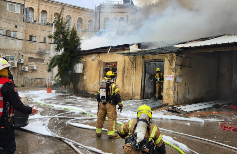  Firefighters douse flames in central Jerusalem after a fire broke out opposite the Bikur Cholim Hospital on February 15, 2023. (photo credit: JERUSALEM FIRE DEPARTMENT)