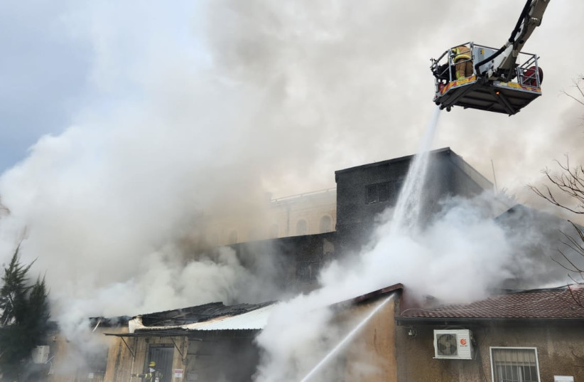  Firefighters douse flames in central Jerusalem after a fire broke out opposite the Bikur Cholim Hospital on February 15, 2023. (credit: JERUSALEM FIRE DEPARTMENT)