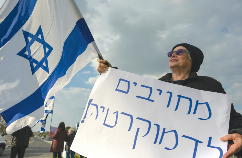  A PROTESTER at a demonstration on Monday holds a sign that reads: ‘[We are] committed to democracy.’  (photo credit: MICHAEL GILADI/FLASH90)