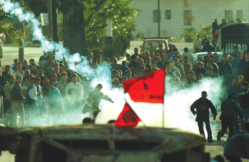  PALESTINIANS THROW tear gas canisters at the IDF in Ramallah, during the early days of the Second Intifada, in October 2000. After the Second Intifada killed the peace camps on both sides, the Zionist dream became a nightmare, says the writer. (photo credit: NATI SHOHAT/FLASH90)