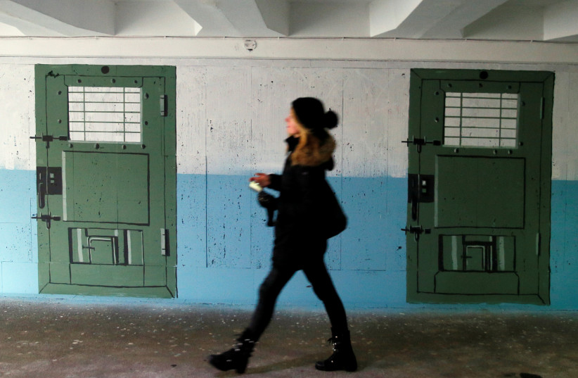  A pedestrian walks in an underpass painted to look like a prison corridor in central Kyiv, Ukraine February 2, 2021 (credit: REUTERS/GLEB GARANICH)