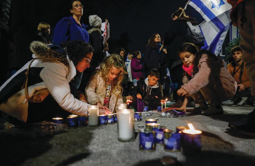  CHILDREN LIGHT candles outside the President’s Residence in Jerusalem in memory of the seven victims of the Neveh Ya’acov synagogue shooting, Jan. 20. (photo credit: OLIVIER FITOUSSI/FLASH90)