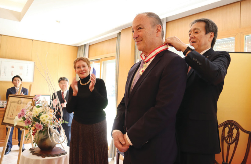  JAPANESE AMBASSADOR Koichi Mizushima fastens the Order of the Rising Sun gold medal around the neck of Zeev Weiss.  (photo credit: Courtesy Embassy of Japan)