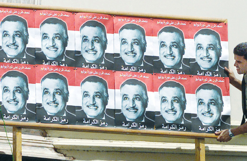  A MAN adjusts a billboard with pictures of former president Gamal Abdel Nasser, in Cairo, July 2002, the 50th anniversary of the revolution when the Free Officers, led by Nasser, seized power from the monarchy. (photo credit: Aladin Abdel Naby/Reuters)