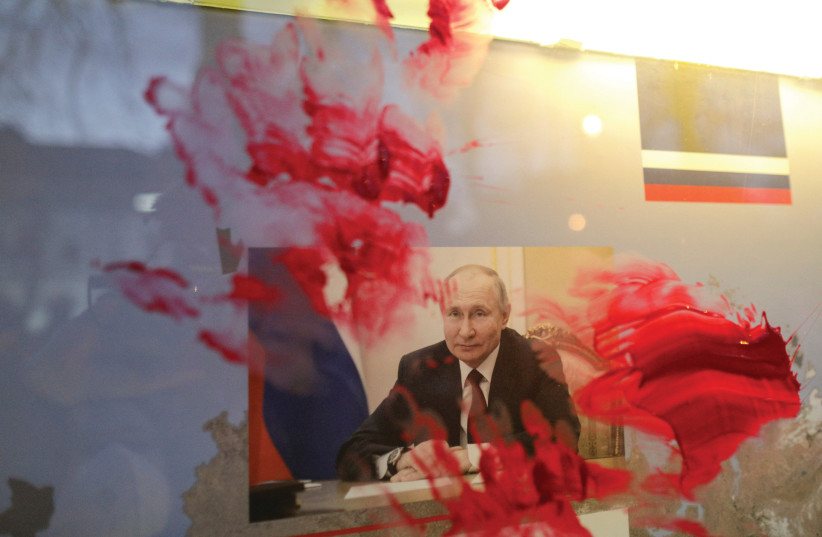  A PORTRAIT of Russian President Vladimir Putin is smeared with red paint during an anti-war protest outside the Russian Embassy in Bucharest, Romania, on February 26, 2022, days after the invasion of Ukraine. (credit: Inquam Photos/Octav Ganea/via Reuters)