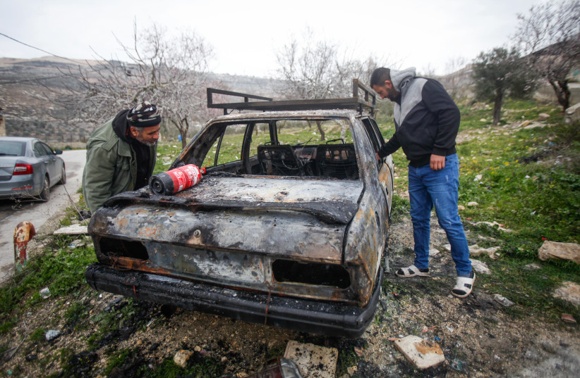 Palestinians examine a burned vehicle set on fire by unknown attackers overnight, in the village of Orif, in the West Bank, February 15, 2023.  (credit: NASSER ISHTAYEH/FLASH90)