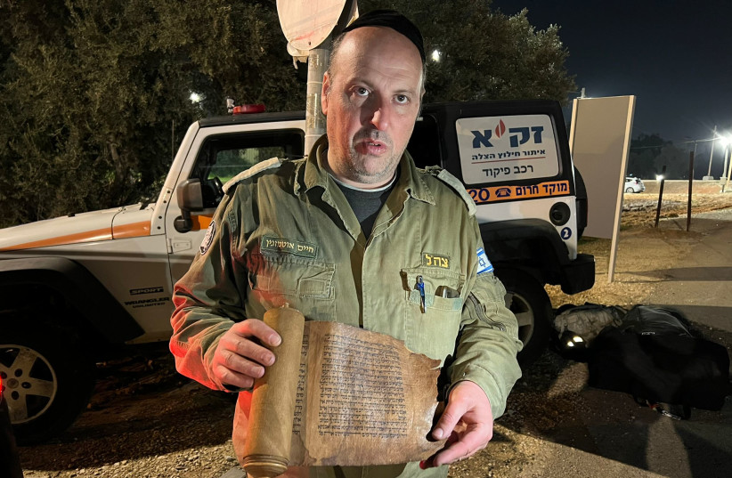  Chaim Otmazgin, commander of ZAKA's team in rescue mission to Turkey, with the ancient Book of Esther scrolls recovered among the ruins of Antakya, Turkey following devastating earthquakes (photo credit: ZAKA)