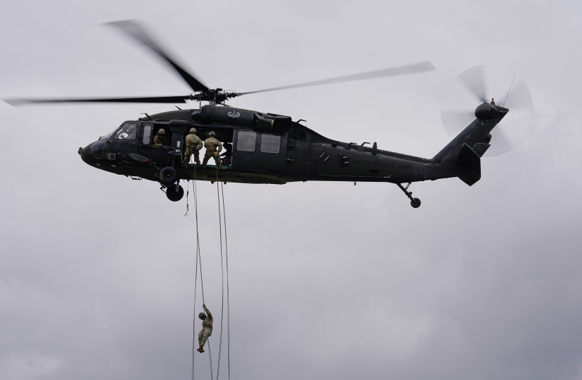 A soldier attending the United States Army Air Assault School rappels from a UH-60 Blackhawk helicopter at Fort Campbell, Kentucky, US, Feb 13, 2020. (photo credit: REUTERS/BRYAN WOOLSTON)