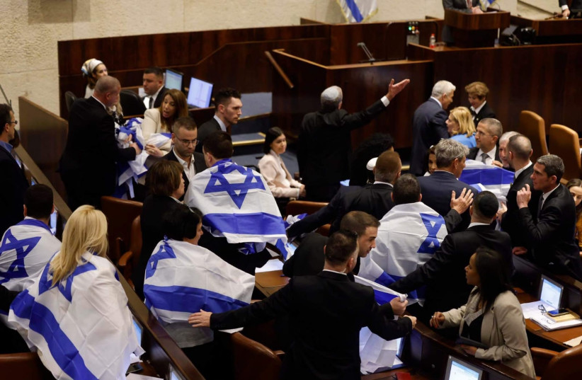  Opposition MKs don Israeli flags in the Knesset Plenum ahead of the first vote on the judicial reform bill, February 20, 2023. (credit: MARC ISRAEL SELLEM/THE JERUSALEM POST)