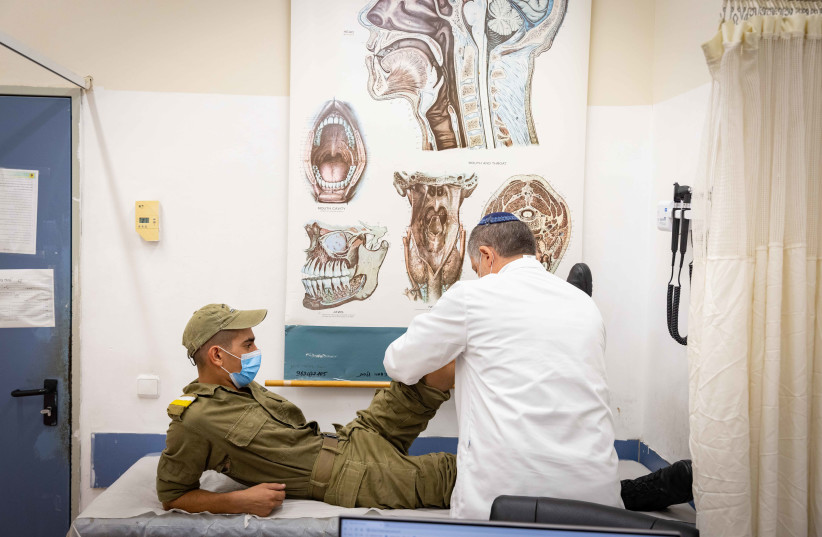  An Israeli Golani soldier is examined by a military doctor during a medical visit at the Golani divisional training base, on August 01, 2021.  (credit: OLIVIER FITOUSSI/FLASH90)