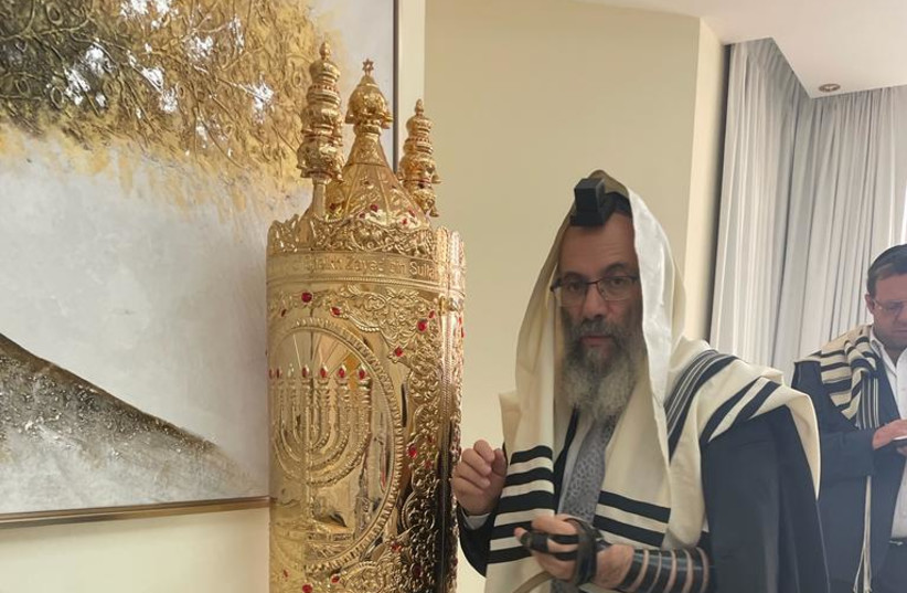  The cut tefillin and Rabbi Moshe Haliwa with the Torah scroll of the governing Sheikh of UAE (credit: Shlomo Haliwa)