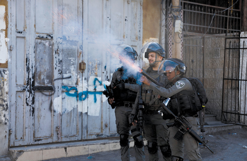  SECURITY FORCES use tear gas during clashes with Palestinians in east Jerusalem on Sunday. (credit: AMMAR AWAD/REUTERS)