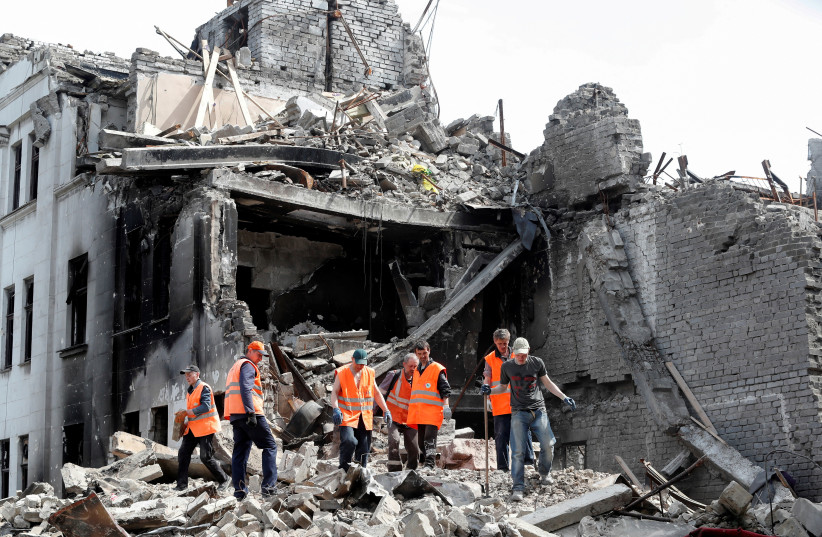  UKRAINIAN EMERGENCY management specialists and volunteers remove the debris of the Mariupol Theater building destroyed in the course of the Ukraine-Russia conflict in the southern port city of Mariupol last year. (photo credit: Alexander Ermochenko/Reuters)
