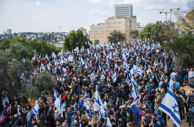  Thousands outside the Knesset in Jerusalem wave the Israeli flag as they protest against the judicial overhaul, on February 13. (photo credit: ERIK MARMOR/FLASH90)
