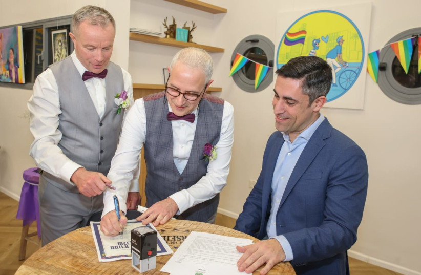 Yuval Reubani and Simon Wrigley sign a civil marriage certificate in honor of Family Day, Ramat Gan, February 21, 2023. (photo credit: CADIA LEVY, RAMAT GAN MUNICIPALITY)