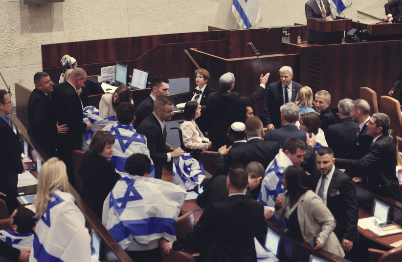   OPPOSITION MKS wrap themselves in Israeli flags during the Knesset vote on judicial reform on Monday night. (photo credit: MARC ISRAEL SELLEM/THE JERUSALEM POST)