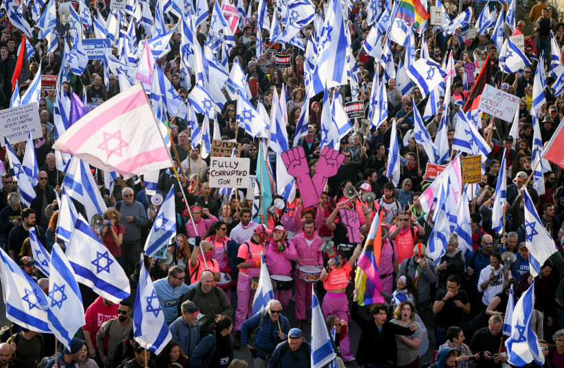  Thousands wave the Israeli flag as they protest against the judicial overhaul, outside the Israeli parliament in Jerusalem. February 20, 2023 (credit: ERIK MARMOR/FLASH90)