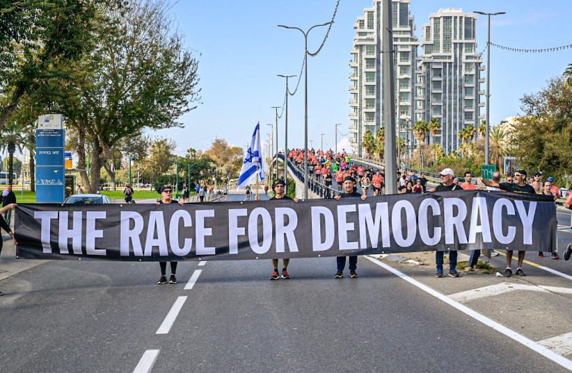  Runners at the Tel Aviv Marathon show their opposition to the judicial reforms. (credit: BEN COHEN)